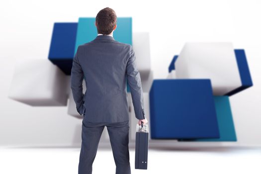 Businessman standing with his briefcase against abstract background