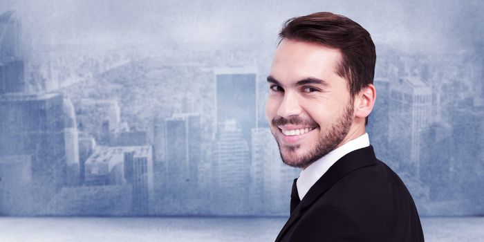 Elegant businessman in suit smiling at camera against city scene in a room