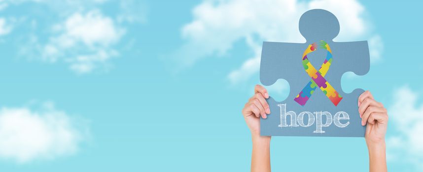 Hands showing jigsaw puzzle against blue sky