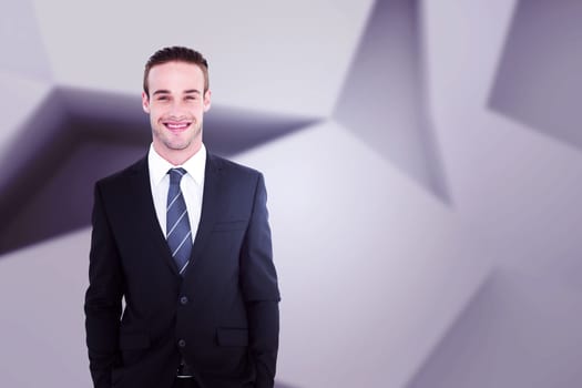 Smiling businessman in suit with hands in pocket posing against abstract room