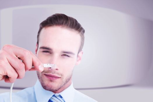 Concentrated businessman holding a cable against white abstract room