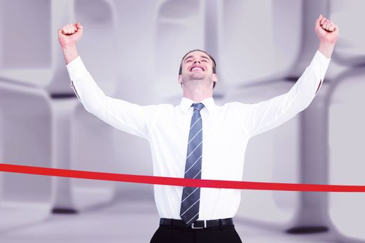 Happy businessman crossing the finish line against white abstract room