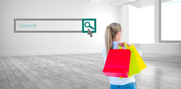 Pretty blonde holding shopping bags against white room with windows