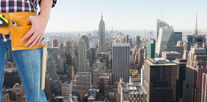 Handyman wearing tool belt against new york