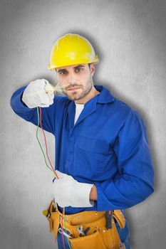 Confident repairman holding cables against white background