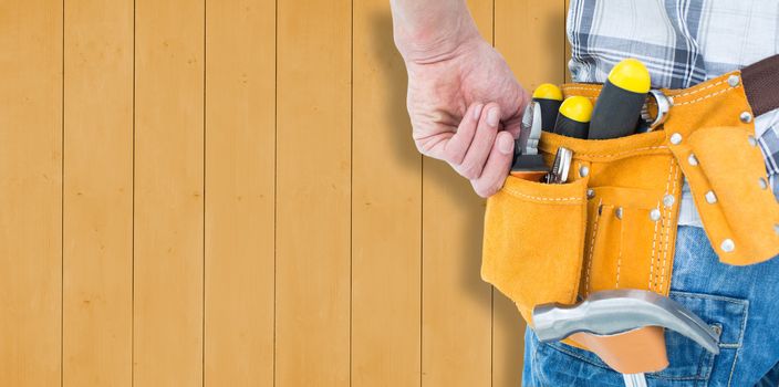 Technician with tool belt around waist against wooden planks