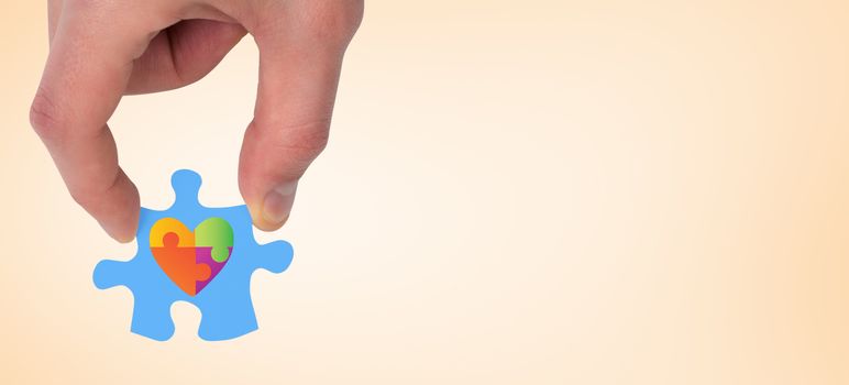 Hand holding jigsaw piece against orange vignette
