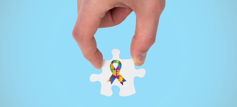 Hand holding jigsaw piece against blue background with vignette