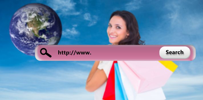 Pretty brunette with shopping bags against blue sky