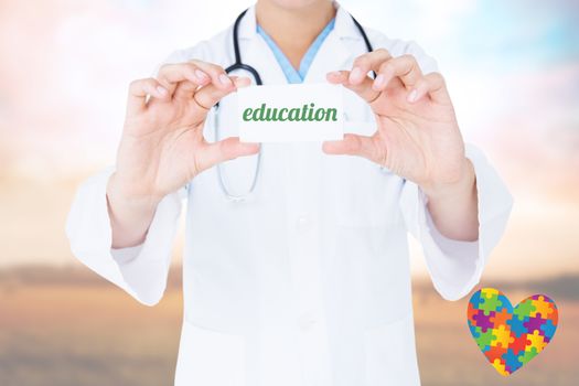The word education and doctor holding card  against countryside scene