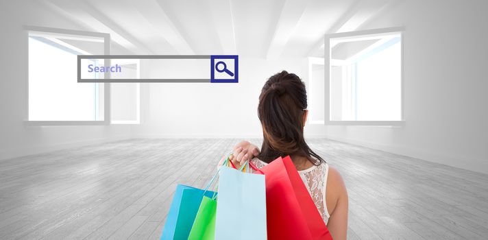 Rear view of brunette holding shopping bags against bright white room with opened windows