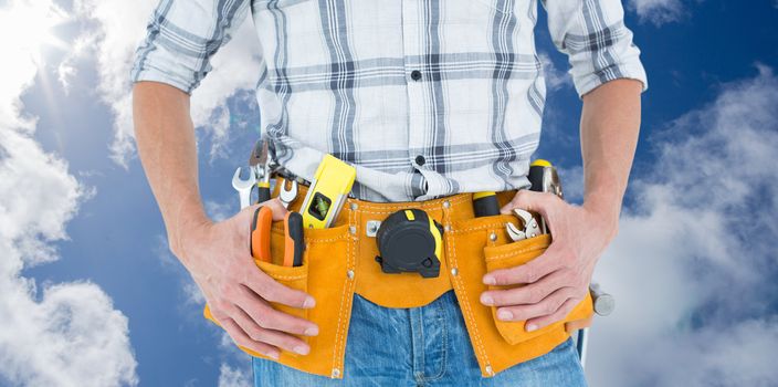 Cropped image of technician with tool belt around waist against bright blue sky with clouds