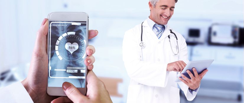 Hand holding smartphone against empty bed in the hospital room