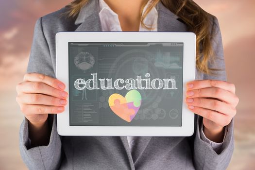 The word education and businesswoman showing a tablet pc against medical biology interface in blue