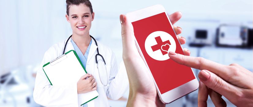 Hand holding smartphone against empty bed in the hospital room