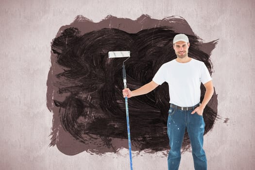 Confident man holding paint roller on white background against white and grey background