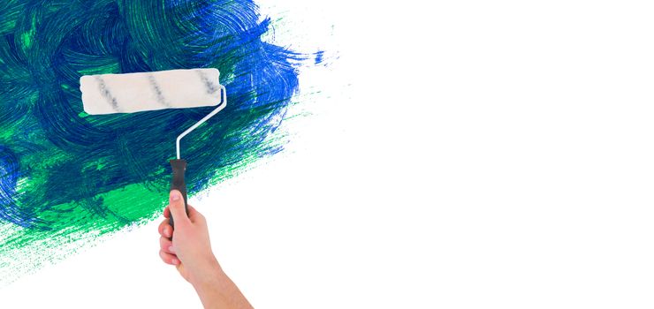 Handyman holding paint roller  against blue and green paint