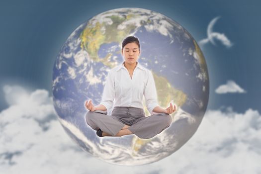 Businesswoman sitting in lotus pose against night sky