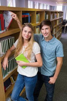 Students smiling at camera in the library in the university 