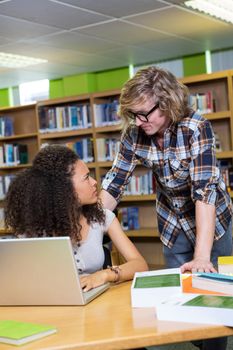 Student getting help from classmate in library at the university