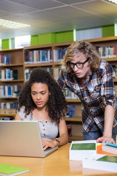 Student getting help from classmate in library at the university