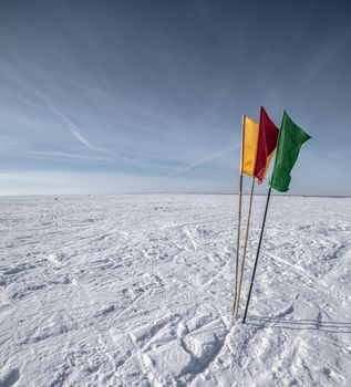 Green, Red, Yellow Flags on the background of winter sky