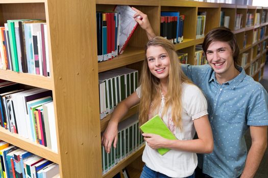 Students smiling at camera in the library at the university 