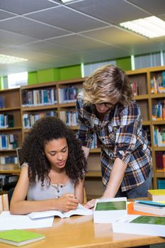 Student getting help from classmate in library at the university