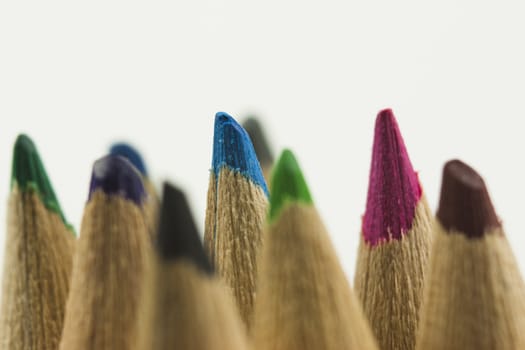 Close f of coloured pencils against a wooden background