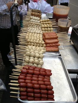 Fried meat balls a grill on a stick in sauce, traditional food in Thailand