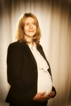 Pregnant blond business woman in black business clothing