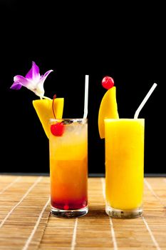 Mango juice and juice soda with fruit on glass isolation black background .