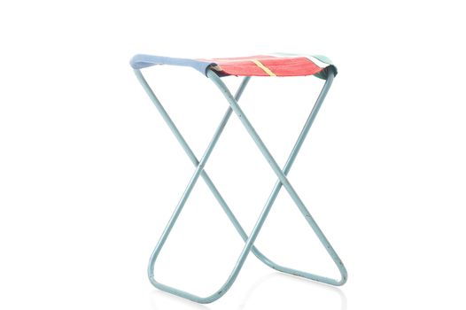 Class metal frame portable folding stool with a canvas or textile seat for picnics and camping viewed unfolded at an oblique angle isolated on white