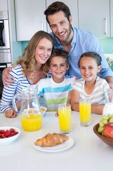 Happy family having breakfast together at home in the kitchen