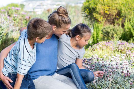 Mother and children tending to flowers in the garden
