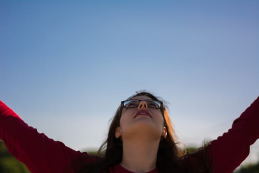 A young beautiful caucasian girl looking the sky.