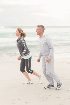 Fit couple jogging together at the beach