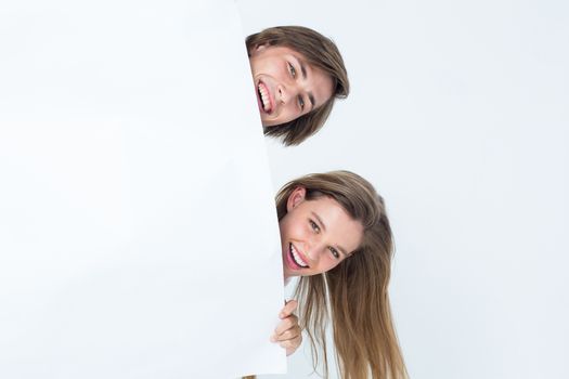 Hipster couple holding poster on white background