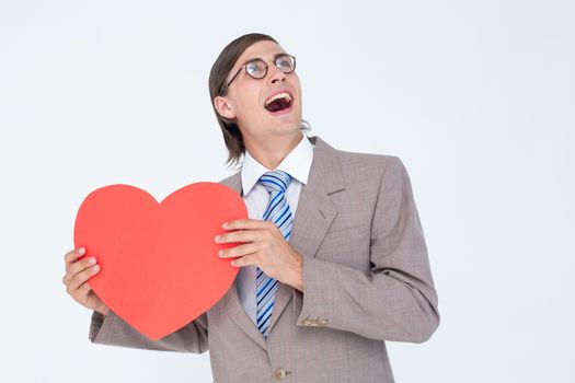 Geeky businessman smiling and holding heart card on white background