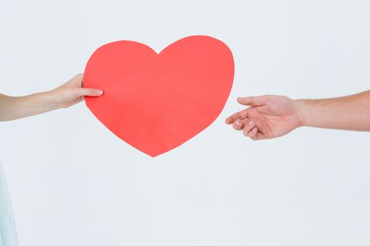 Woman giving heart card to her boyfriend on white background