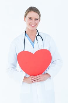 Doctor holding red heart card on white background 