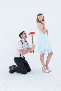 Geeky hipster begging his girlfriend taking roses on white background