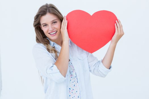 Woman holding heart card on white background 