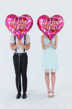 Geeky hipster couple with balloons in front of their head on white background