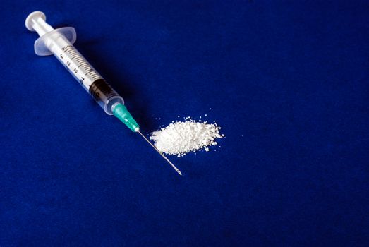 Medical syringe and drug on blu background