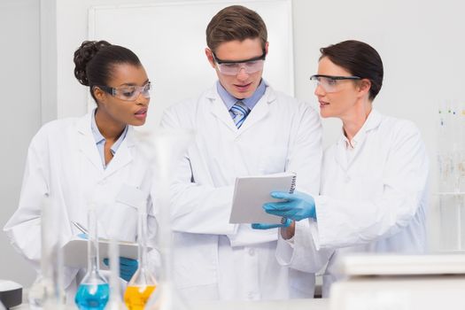 Scientists looking at clipboard in laboratory  