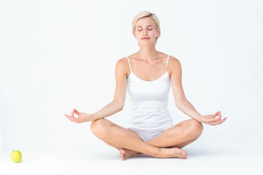  Fit woman doing yoga on white background