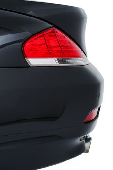 Rear red tail light, reflector and bumper of a modern black car viewed close up side on isolated on white