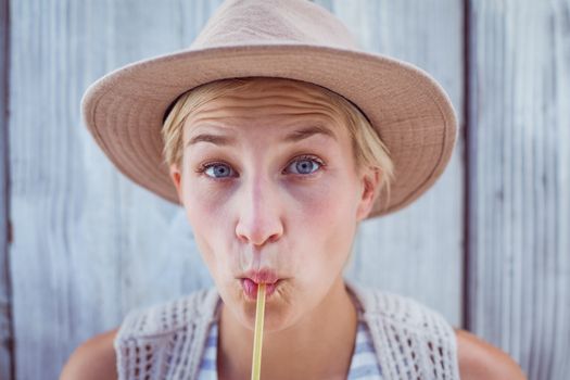 Pretty blonde woman drinking orange juice on wooden background