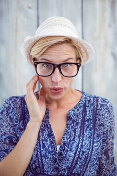 Pretty blonde woman wearing hipster glasses on wooden background